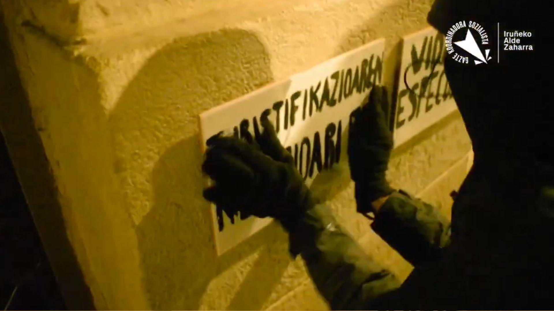 Fotograma del vídeo publicado en redes sociales por Iruñerriko Gazte Koordinadora Sozialistaren (GKS) en el que varios encapuchados de negro vandalizan uno de los locales de la empresa Vidaurre