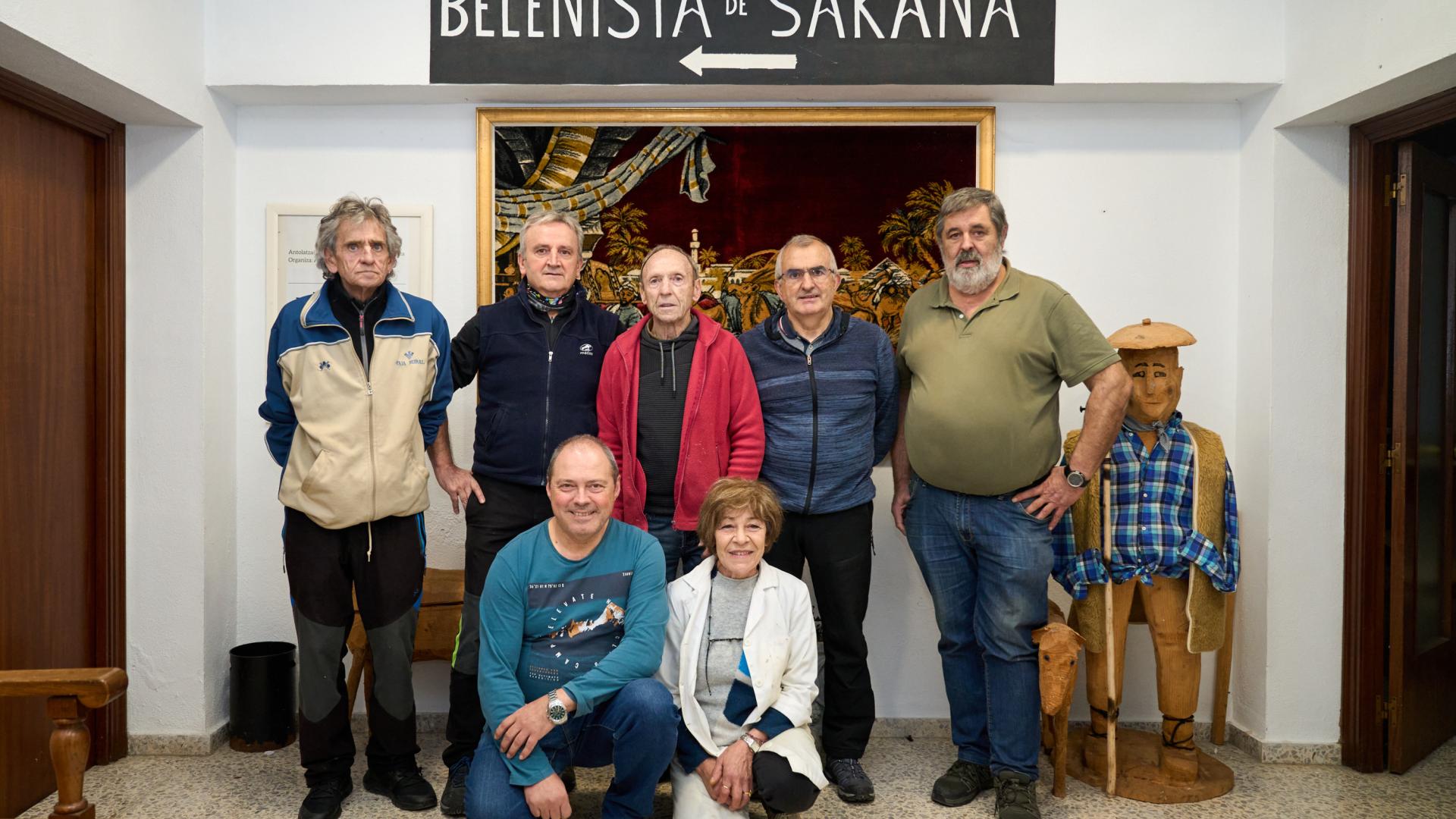 De izquierda a derecha, Javier Beunza Lorea, Patxi Aguirre Baztarrica, Jesús María Garmendia Mauleón, Luis Borrega Santano y Felipe Orabengoa Velasco. Agachados, José Luis Resines Lasaga y Katy Mayor Villarejo, en el acceso al antiguo consultorio de Olazagutía donde se expondrán las doce creaciones de la Asociación de Belenistas de Sakana.
