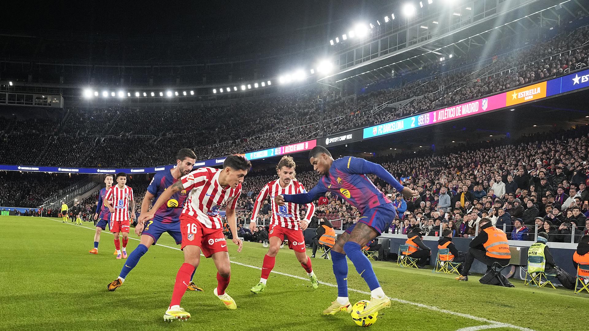 El delantero británico del FC Barcelona, Marcus Rashford (d), protege el balón ante el defensa argentino del Atlético de Madrid, Nahuel Molina