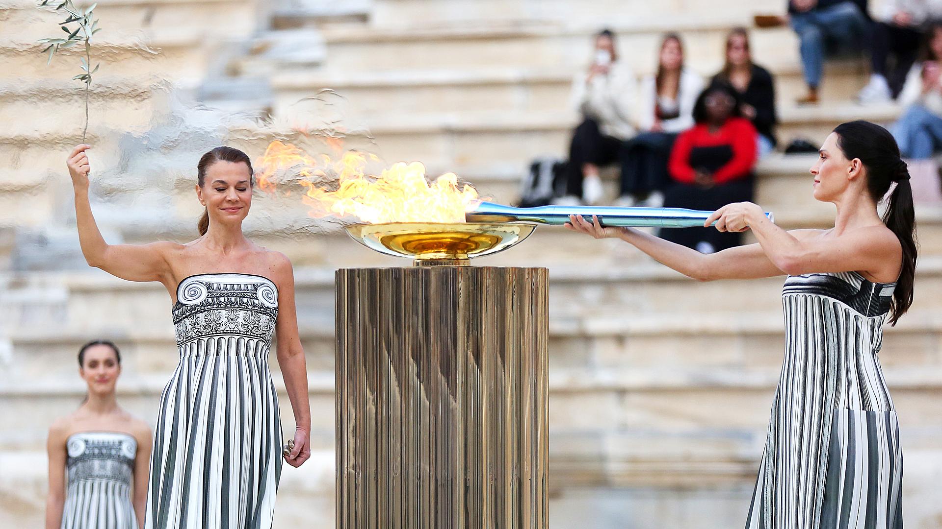 La actriz griega Mary Mina, en el papel de la Suma Sacerdotisa, enciende la Antorcha Olímpica durante la ceremonia de entrega de la Llama Olímpica para los Juegos Olímpicos de Invierno Milano Cortina 2026, en el Estadio Panatenaico de Atenas, Grecia