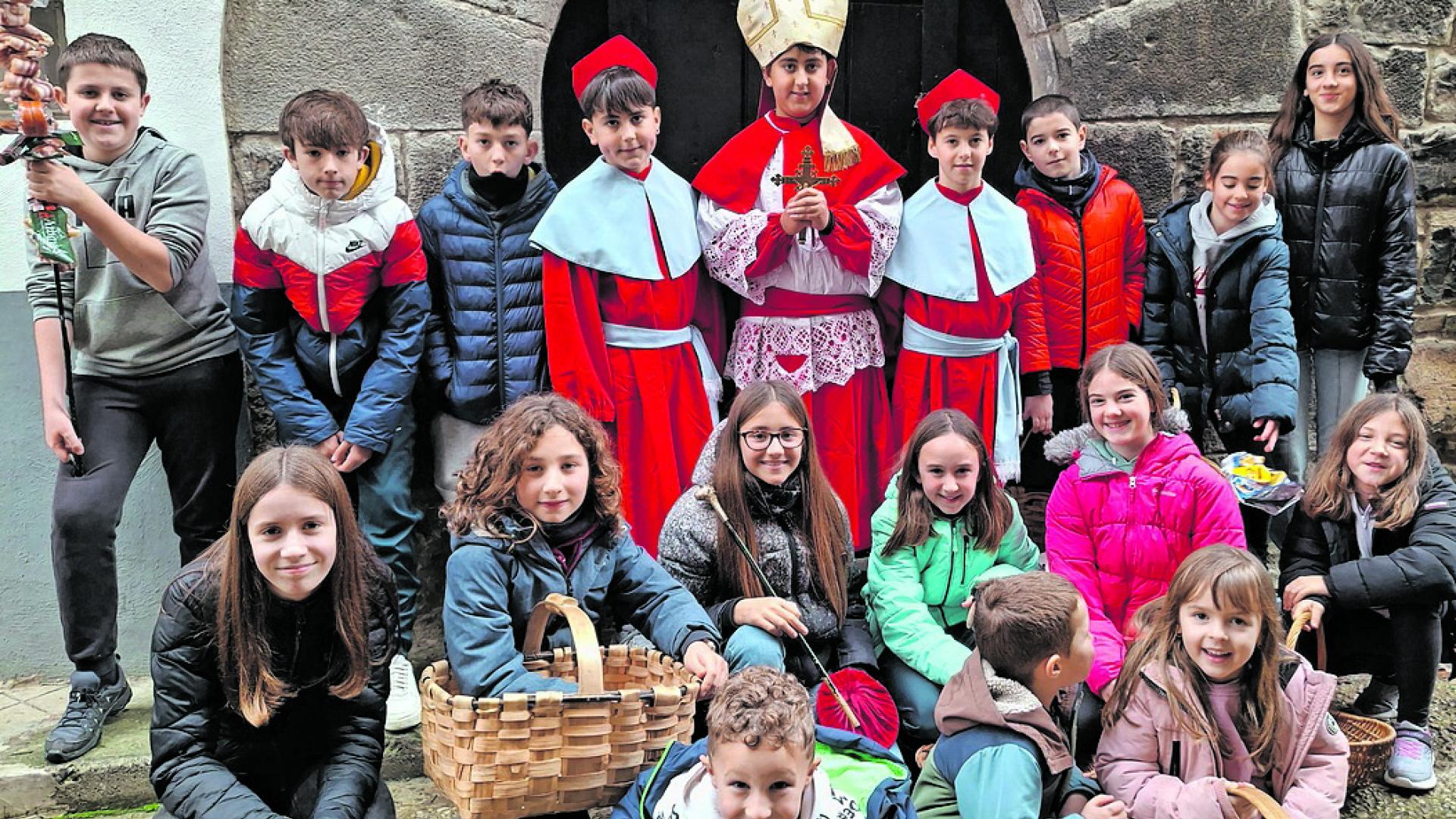 Escolares de Burgui con el obispo en el centro, en la cuestación ayer por las casas del pueblo.