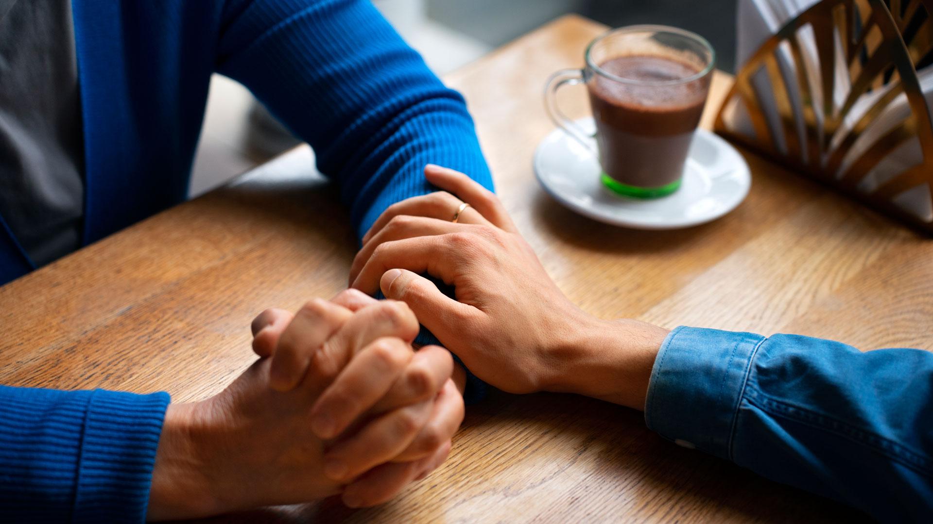 Una persona muestra su apoyo y empatía a otra tocándole el brazo