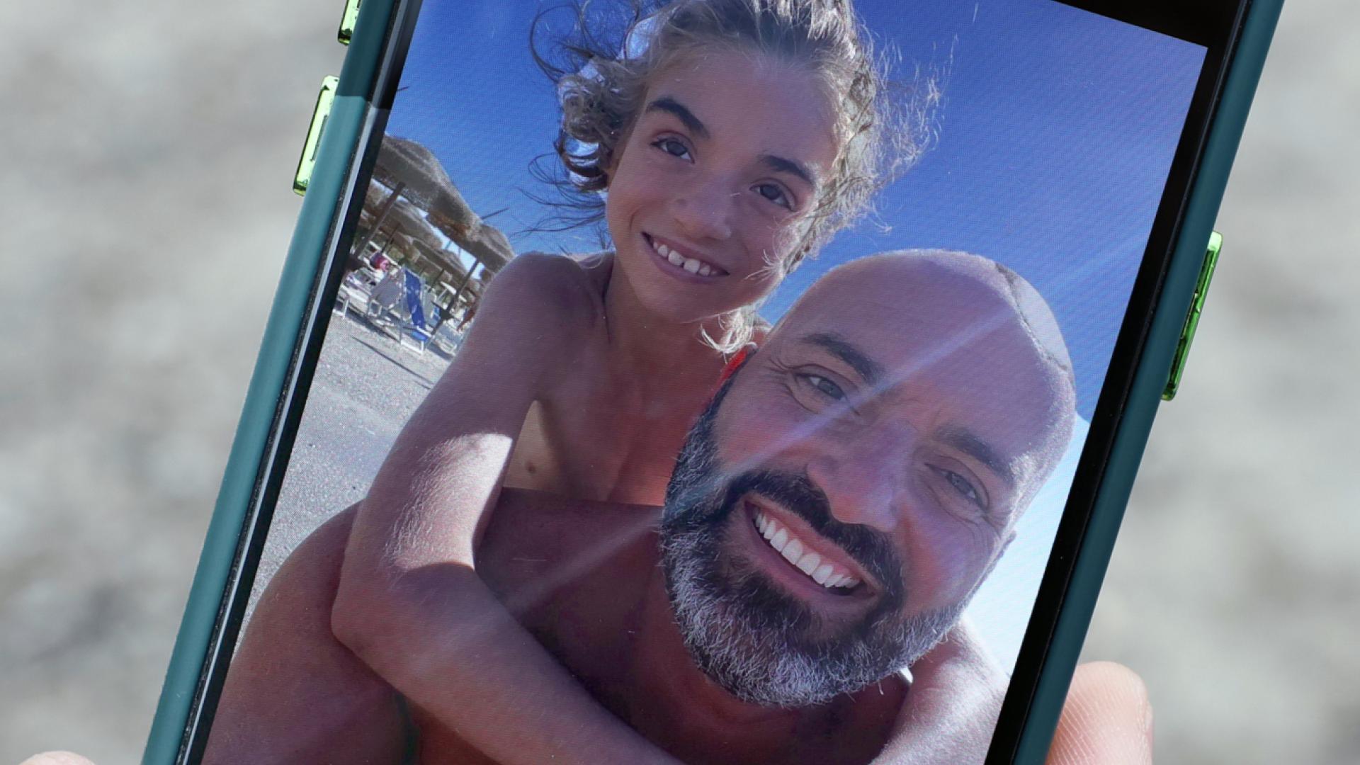 Armando camina por su hija Gioia, de nueve años, en la pantalla del móvil.