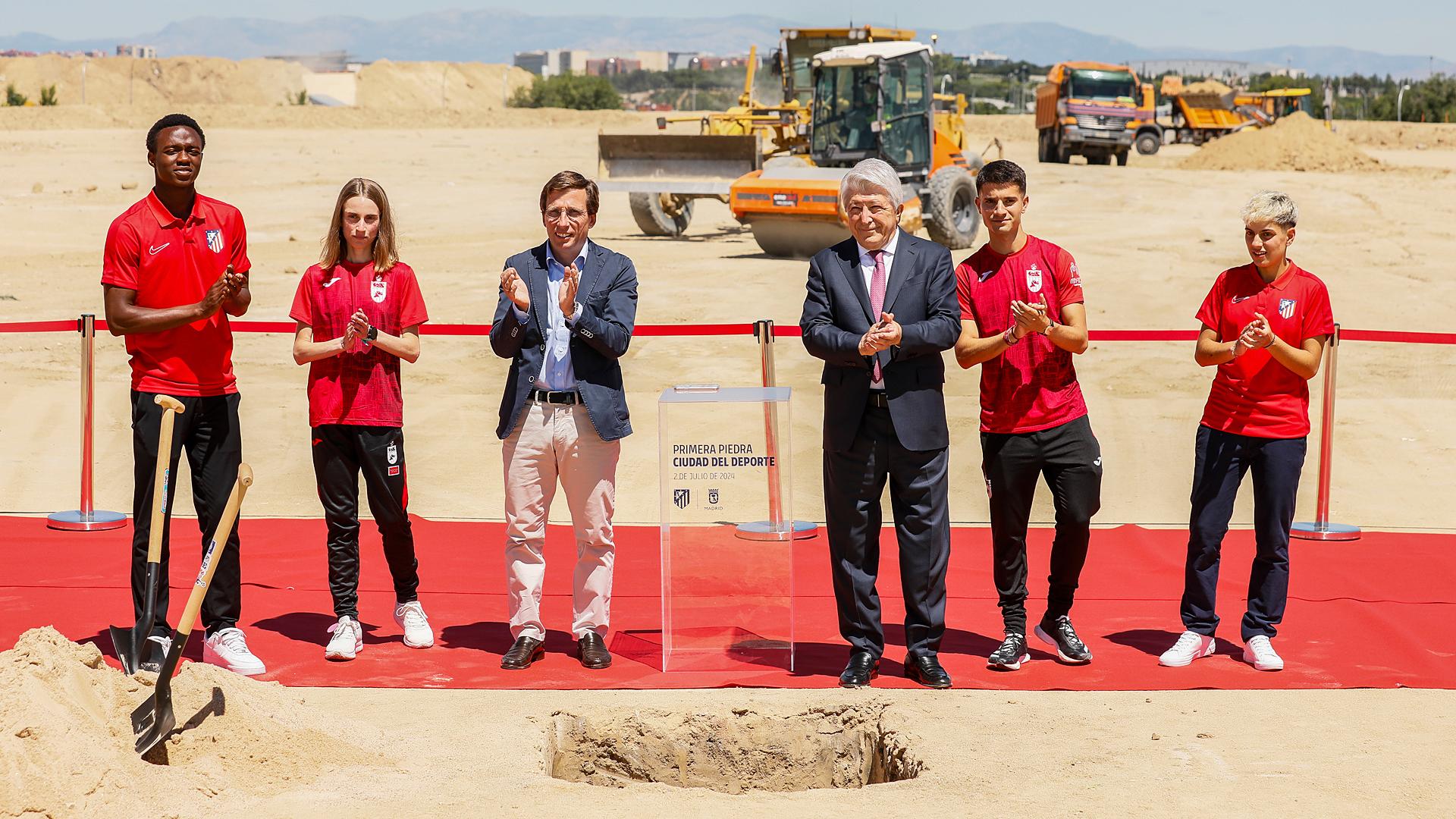 El alcalde de Madrid, José Luis Martínez Almeida, y el presidente del Atlético de Madrid, Enrique Cerezo, en la puesta de la primera piedra de la Ciudad del Deporte junto a promesas de la cantera del equipo rojiblanco y dos atletas del club de Suances en julio de 2024