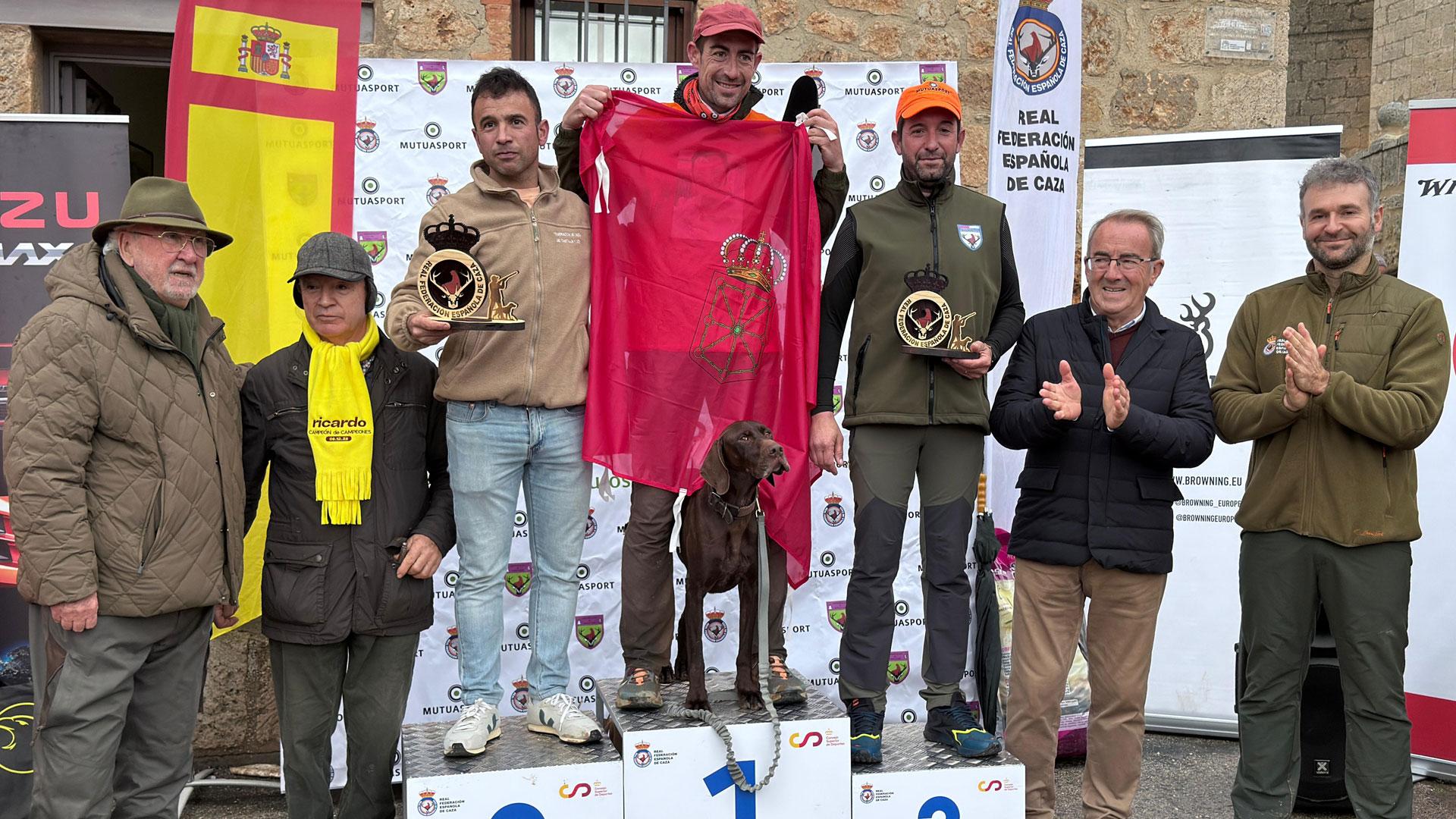 César Bayo, en lo alto del podium como ganador del Campeonato de España de caza menor con perro, junto al segundo y tercer clasificado y las autoridades asistentes