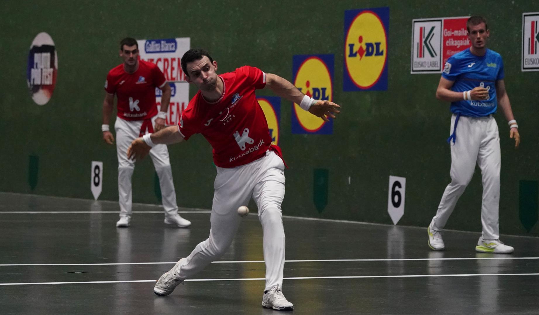 Jokin Altuna golpea a la pelota en presencia de Mariezkurrena y Ezkurdia.