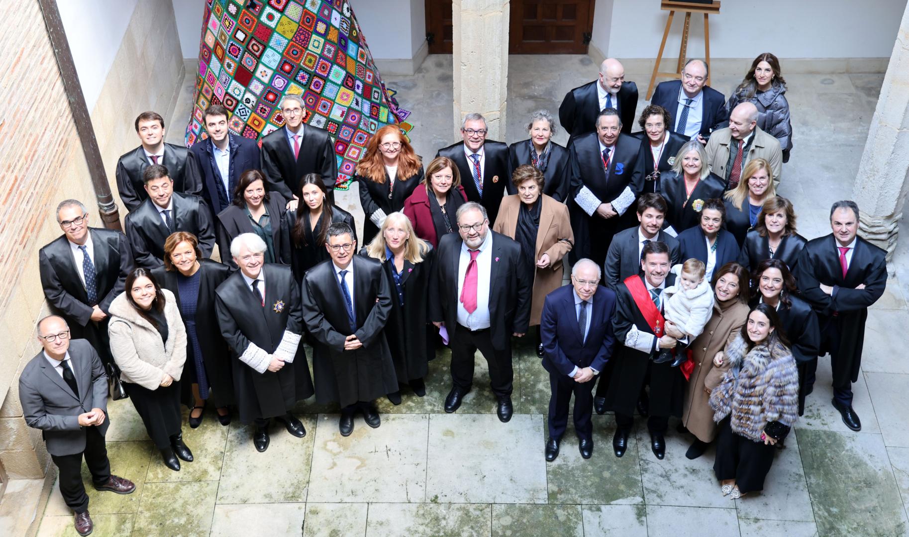 Foto en el patio de la casa de cultura con compañeros abogados, nuevos colegiados, autoridades y el decano Bernardo Lacarra, a la derecha de la imagen rodeado de su familia y con su nieta en brazos.
