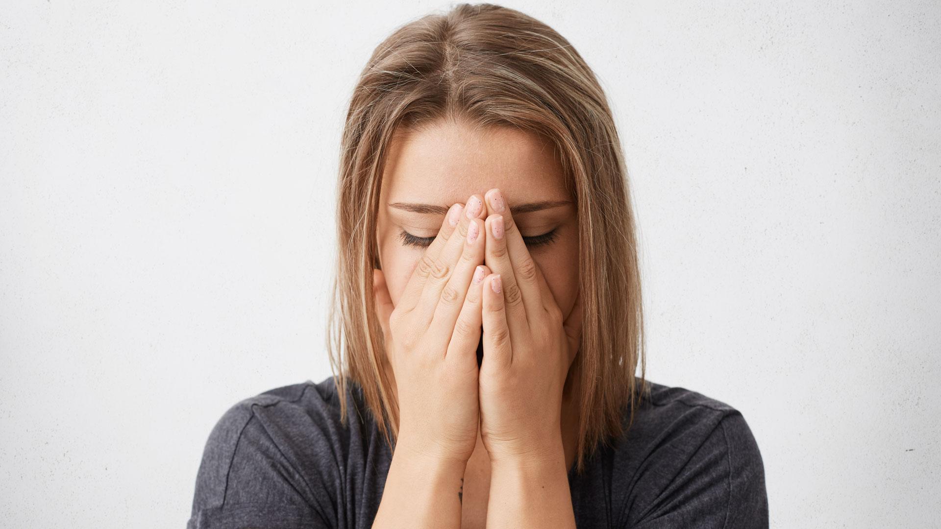 Una mujer se tapa la cara para llorar