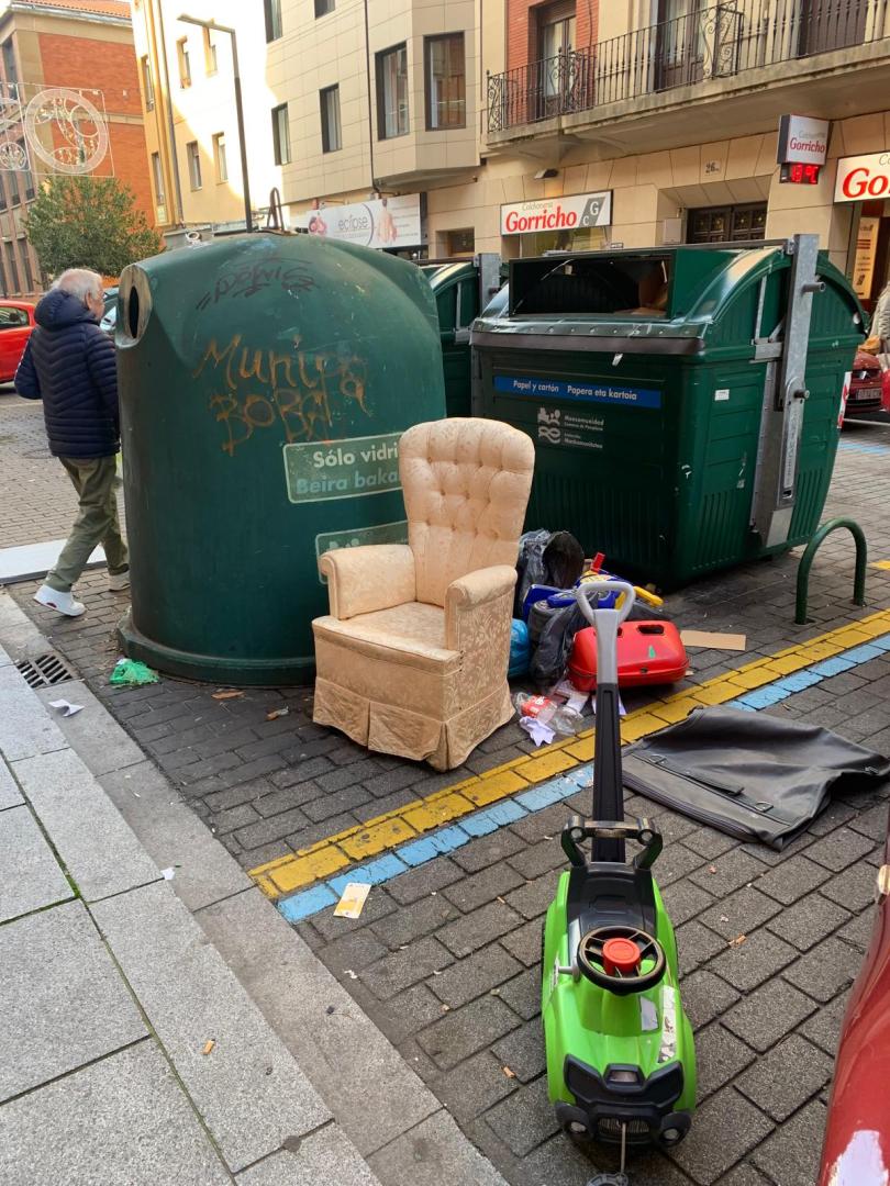 Un sillón y otros enseres abandonados junto a un contendor en la calle Tafalla de Pamplona, este 18 de diciembre.