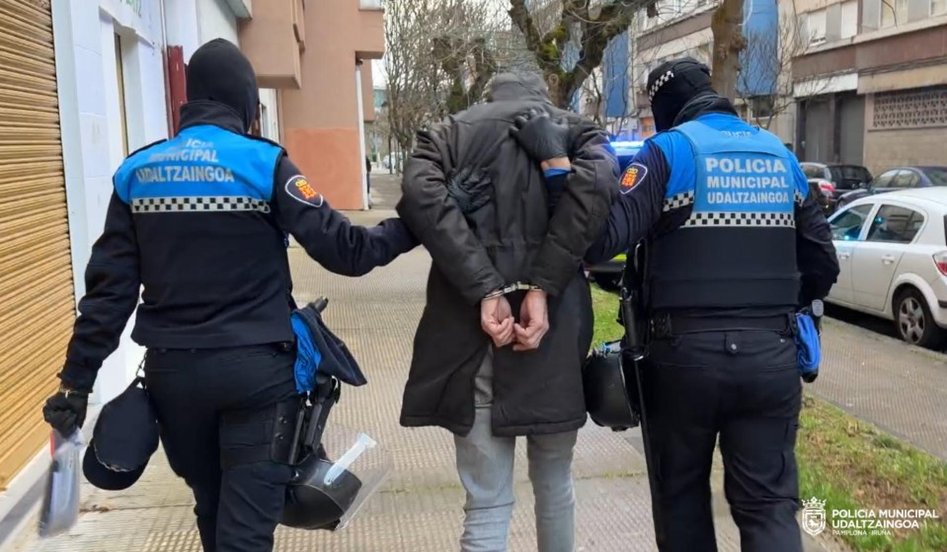 Dos agentes junto a uno de los dos detenidos