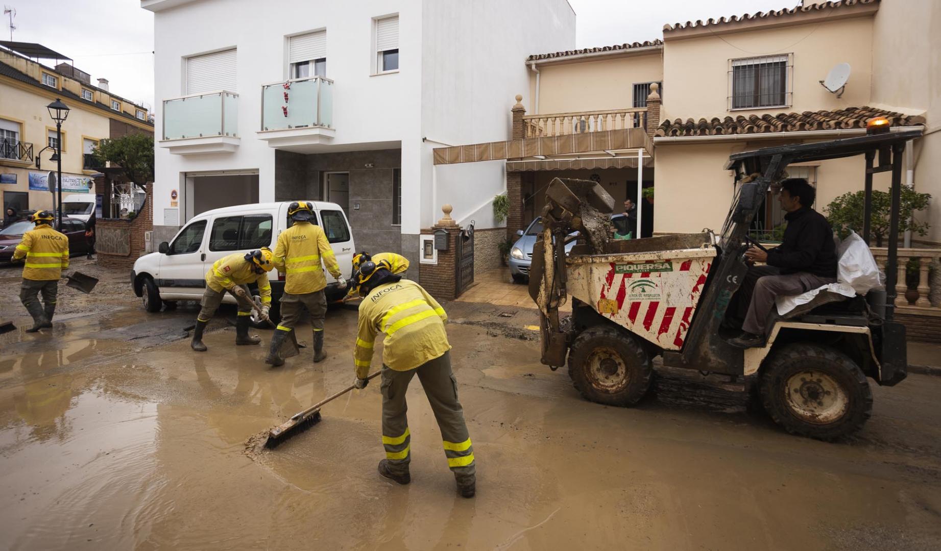 Labores de limpieza de las calles este domingo en Estación de Cártama después de los problemas sufridos anoche en la localidad por la crecida del río Guadalhorce