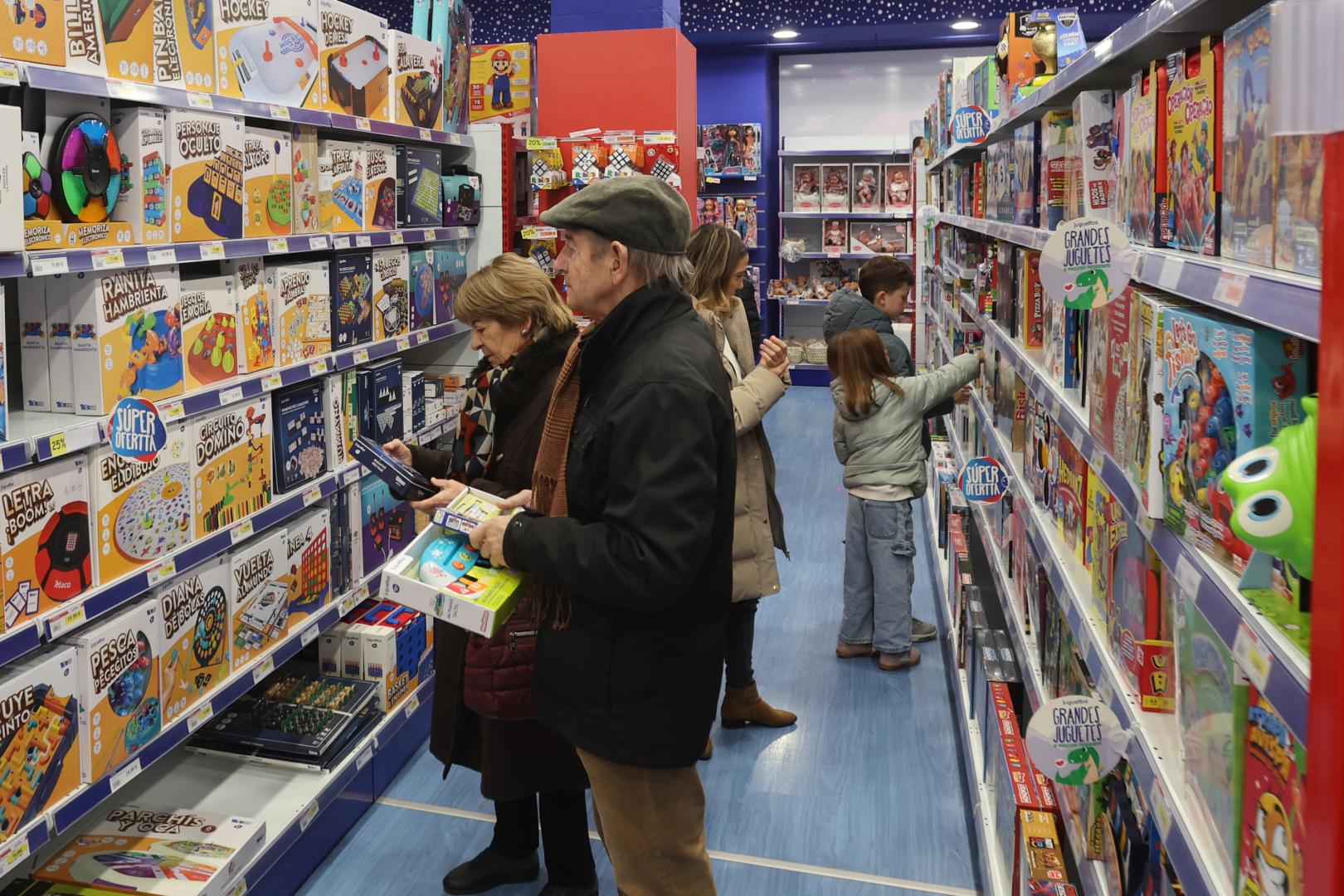 Tres generaciones distintas eligen sus regalos para los Reyes Magos en una juguetería de Pamplona