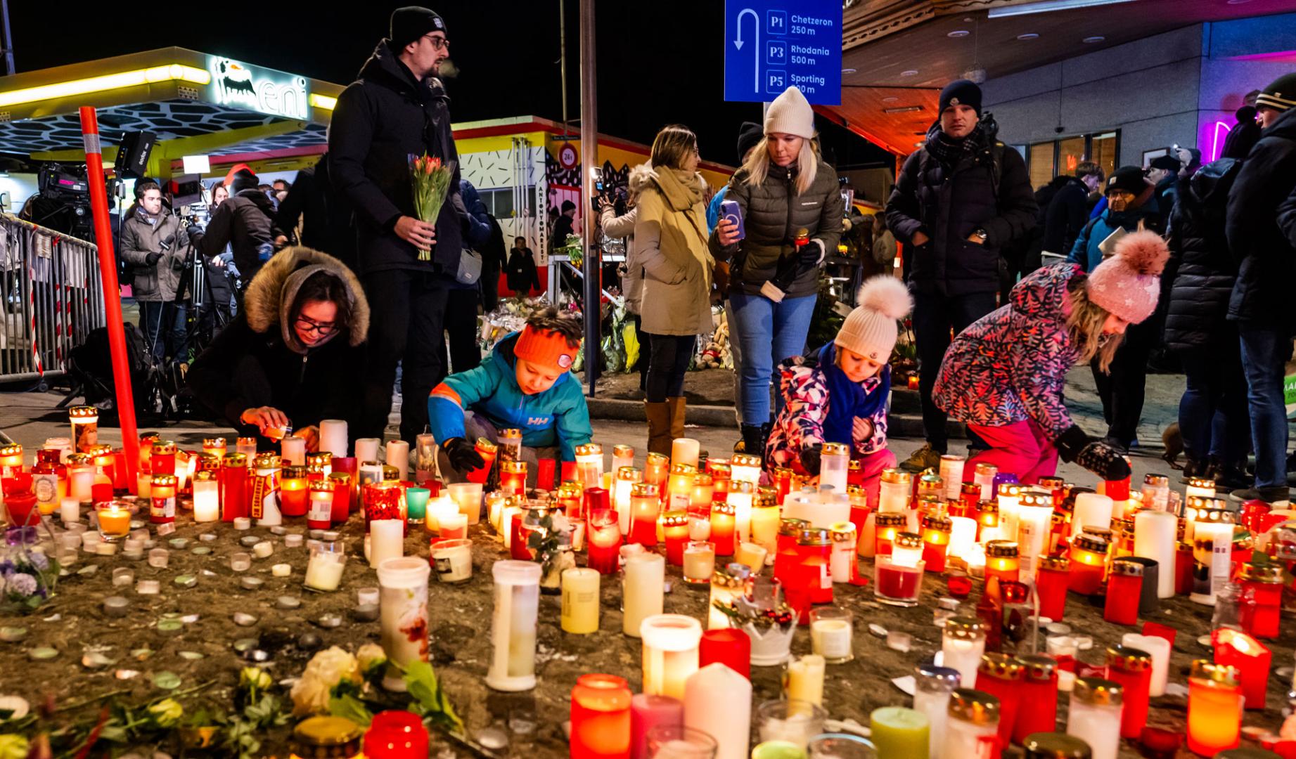 Varias personas colocan velas en memoria de los fallecidos en Suiza