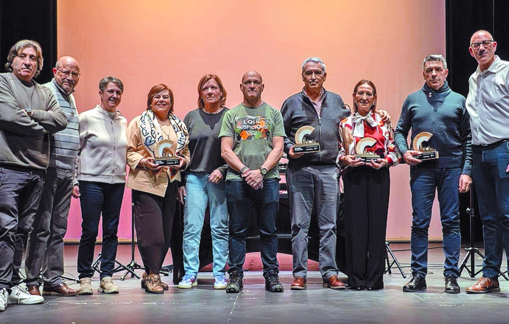 Trabajadores jubilados posan en el escenario tras recibir el homenaje.