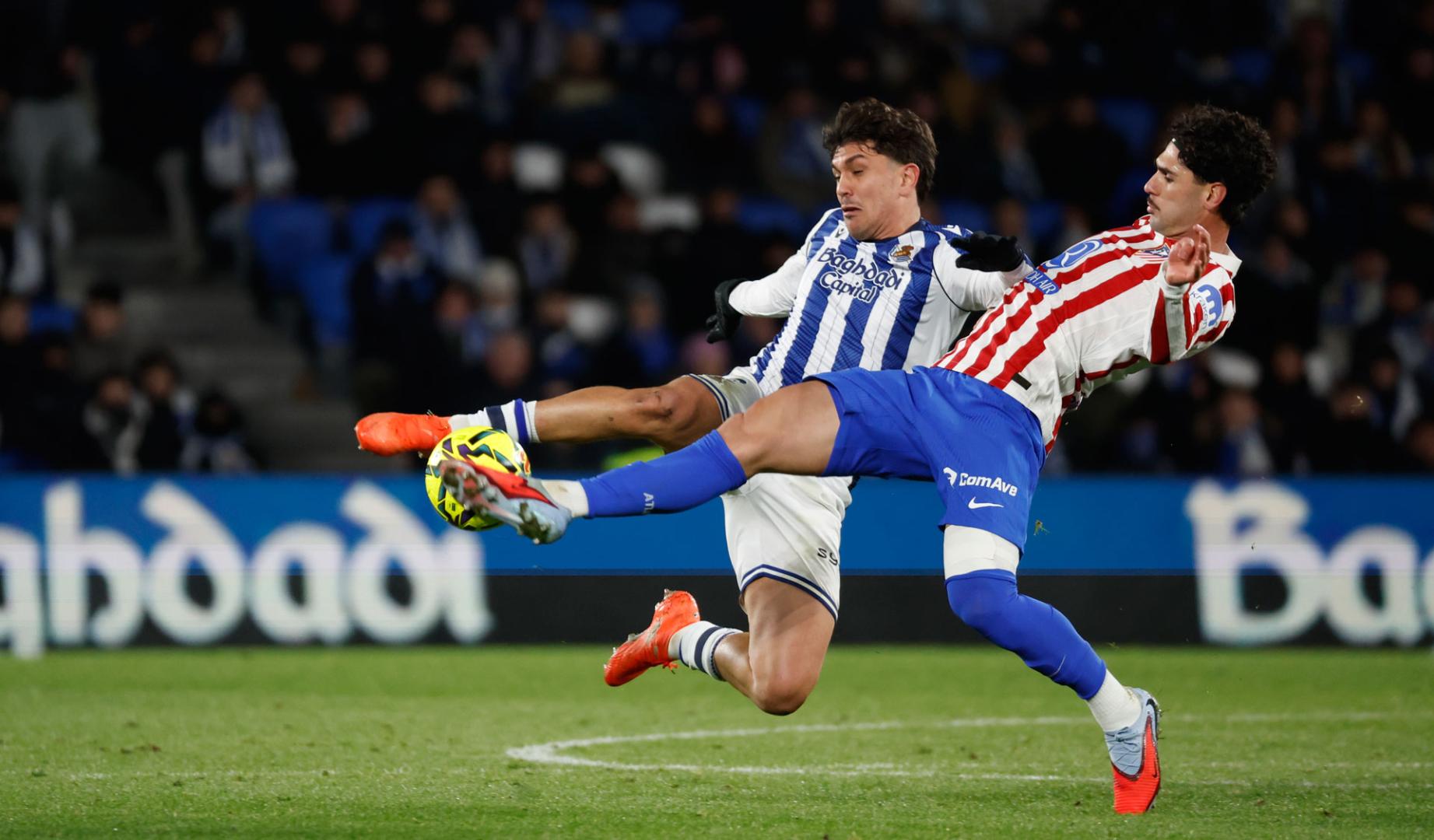 El centrocampista del Atlético de Madrid Jonny Cardoso (d) lucha con Jon Aramburu, de la Real Sociedad, durante el partido