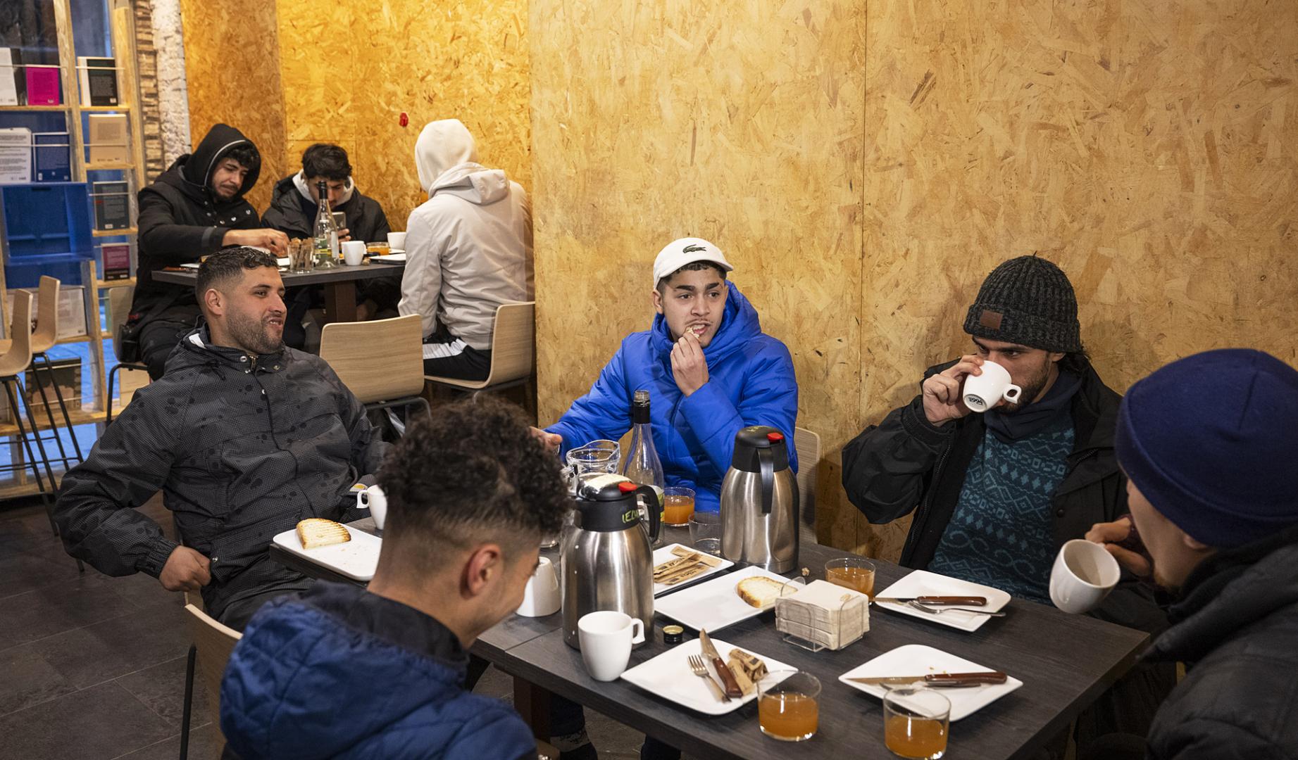 Algunos de los jóvenes sin hogar que pasaron su primera noche en la librería, durante el desayuno