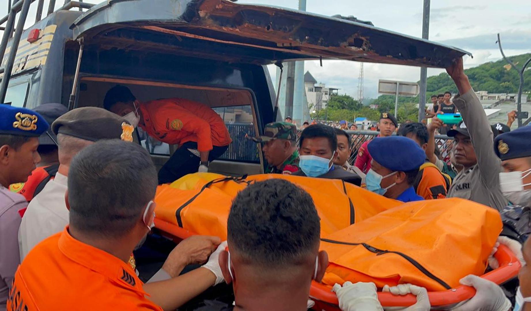 Los equipos de rescaten introducen en un vehículo los restos del cuerpo sin vida del niño recuperado de las aguas