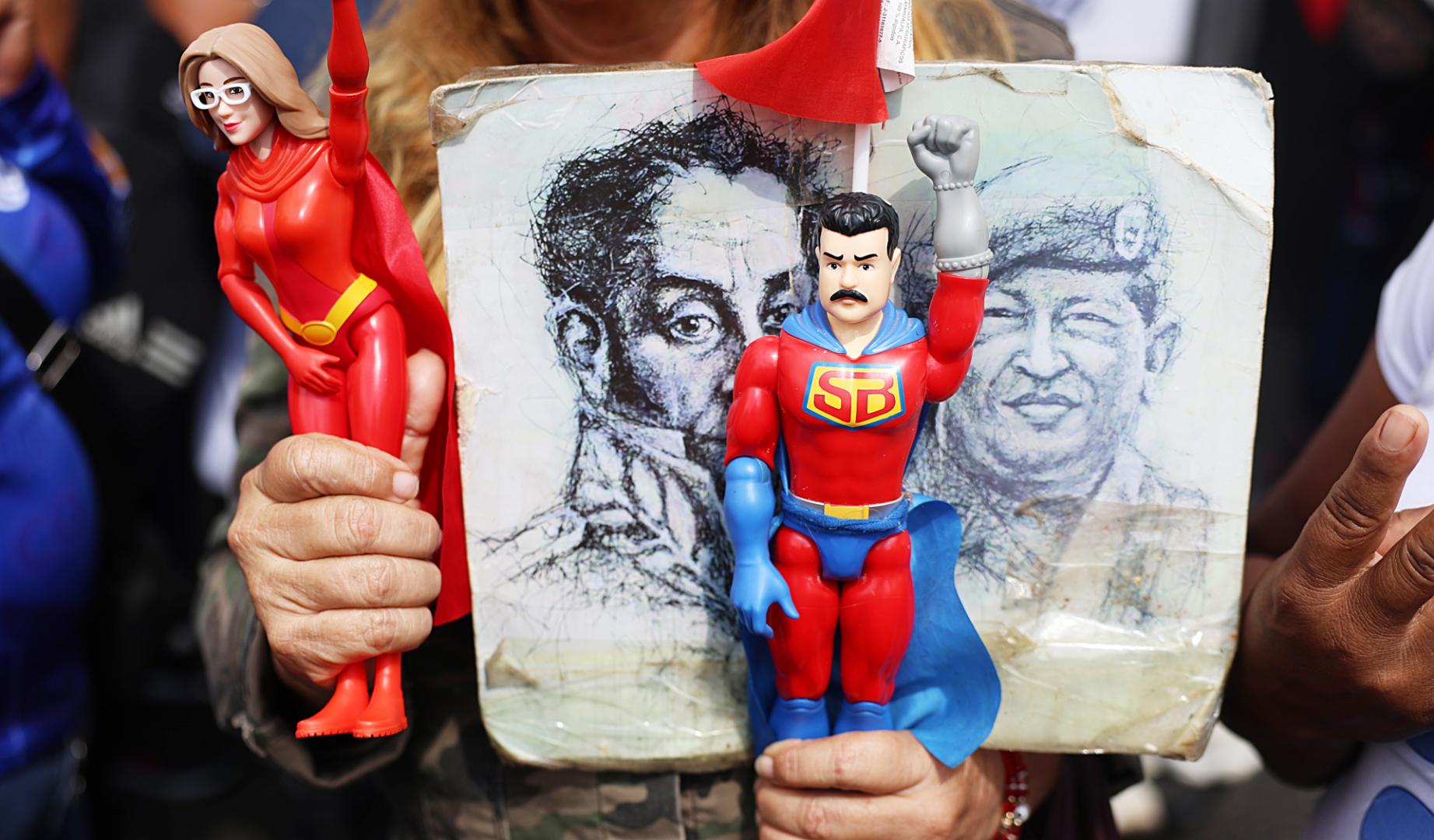 Un simpatizante de Maduro sostiene figuras del presidente de Venezuela, Nicolás Maduro, y de su esposa Cilia Flores, durante una manifestación de simpatizantes del oficialismo