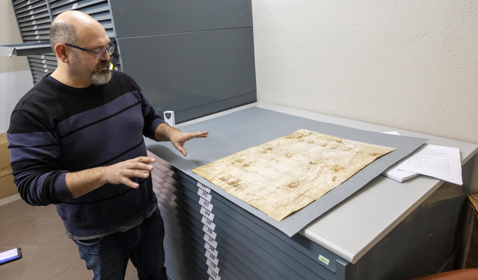 El pergamino -en la imagen siendo explicado por el archivero de Tudela Íñigo Pérez Ochoa- contiene los retratos de 25 miembros de la familia Olaso, 17 de los cuales fueron vecinos de Tudela