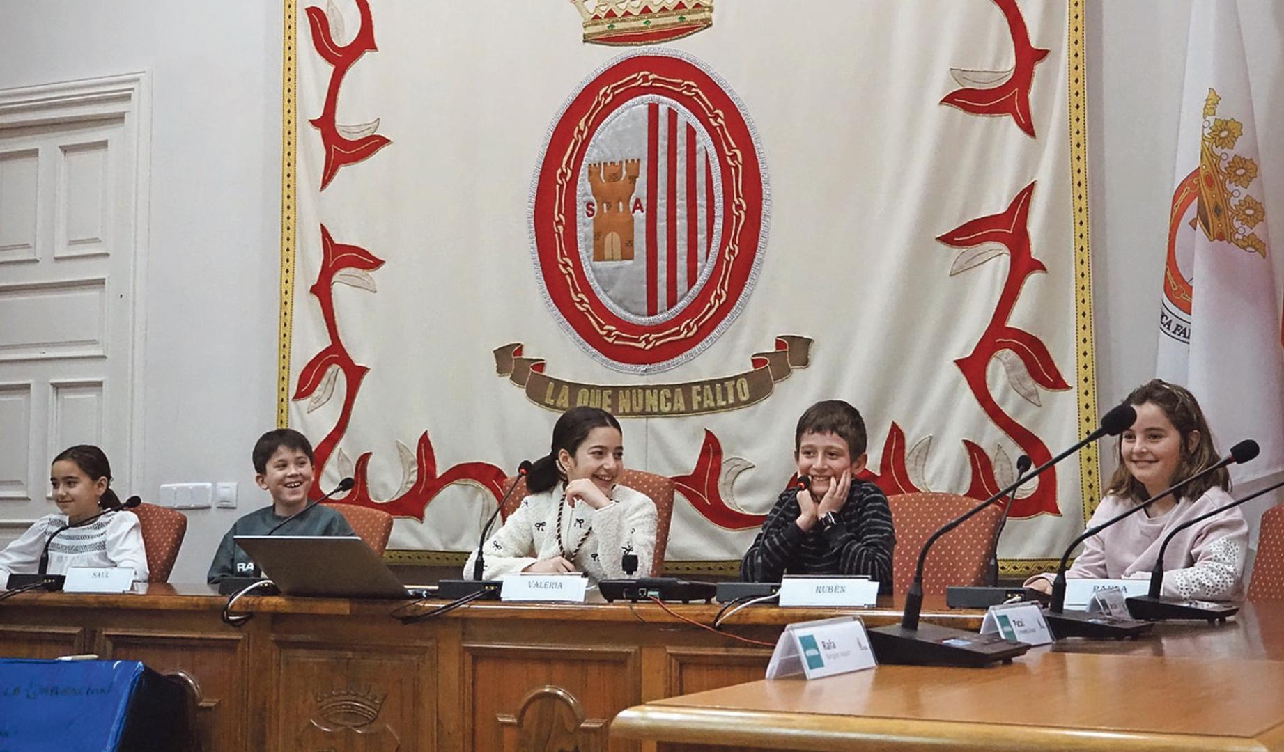 Gestos cómplices entre la corporación txiki de Sangüesa durante el pleno infantil de este sábado
