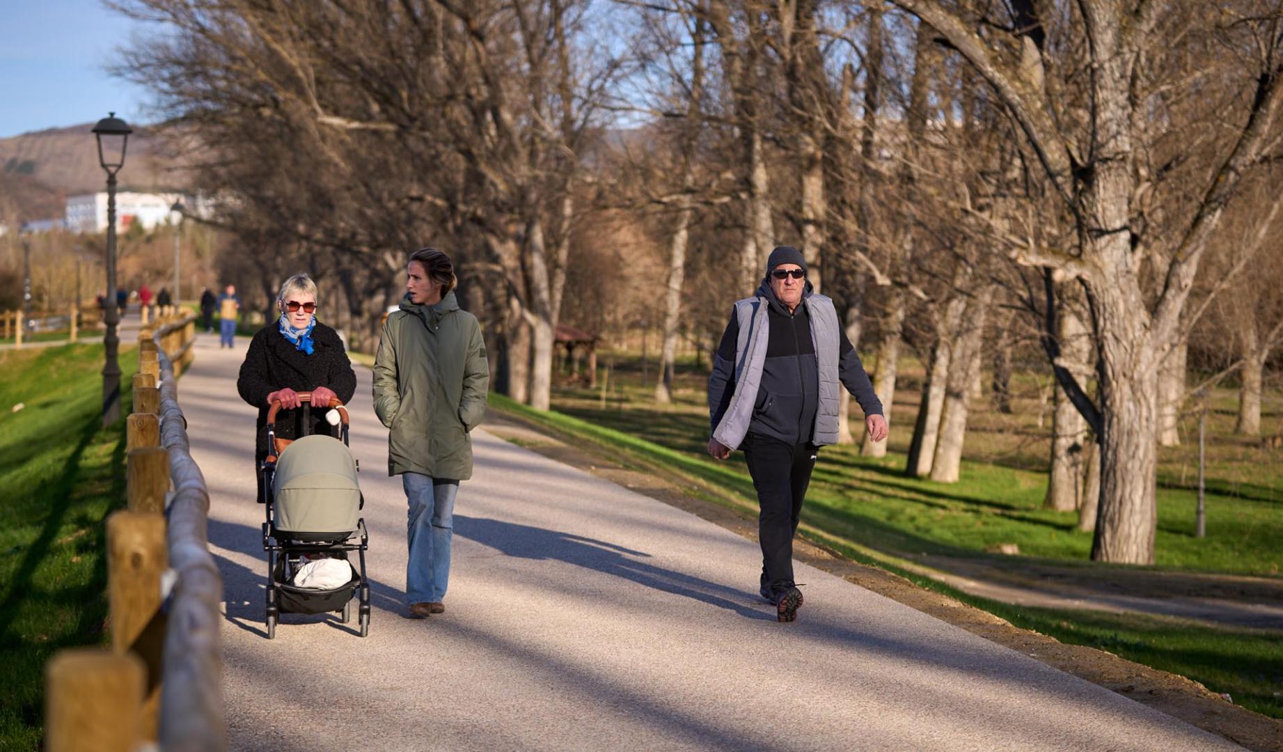 Personas paseando por el nuevo camino acondicionado sobre la mota que se ha retranqueado y ganado en altura en el parque de la Nogalera.