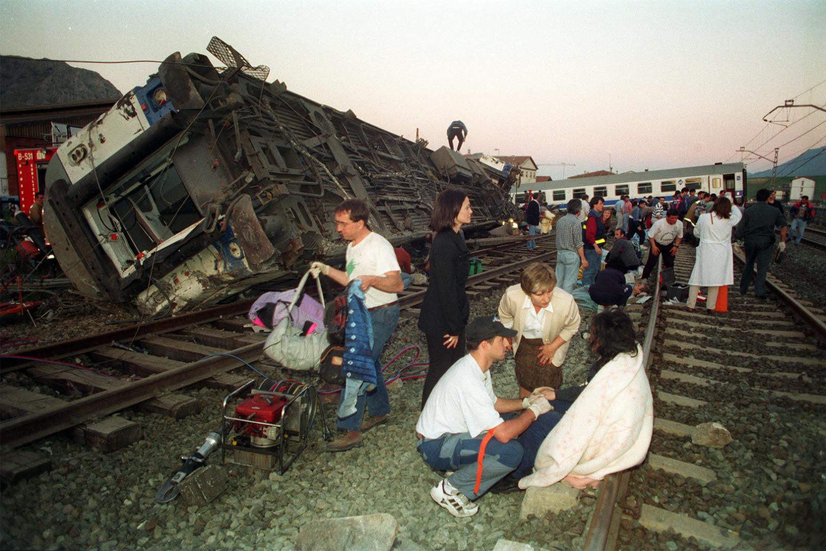 Javier Landibar, con gorra, atendiendo a una mujer herida en el accidente de tren.