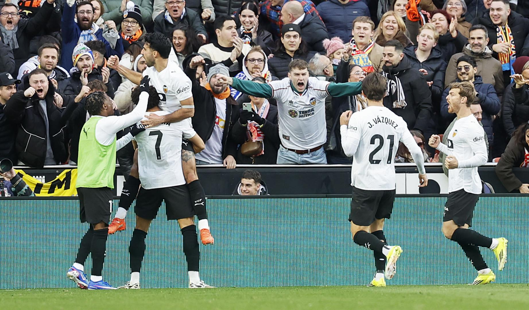 El defensa suizo del Valencia Eray Cömert (3i) celebra su gol ante el Espanyol