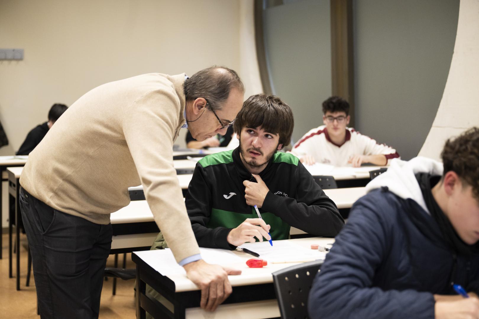 El profesor de la UPNA Gustavo Ochoa atiende una consulta de Oroel Villanúa, ganador de la fase local de la Olimpiada Matemática.