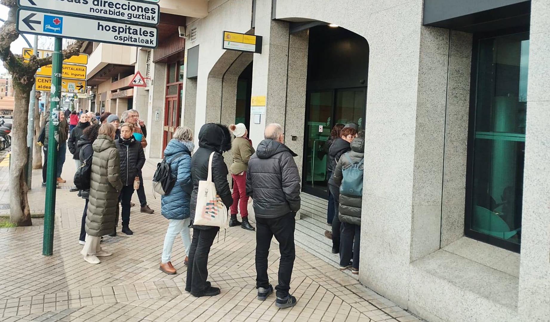 Varias personas esperan ante las puertas de la oficina de la Seguridad Social en Pamplona