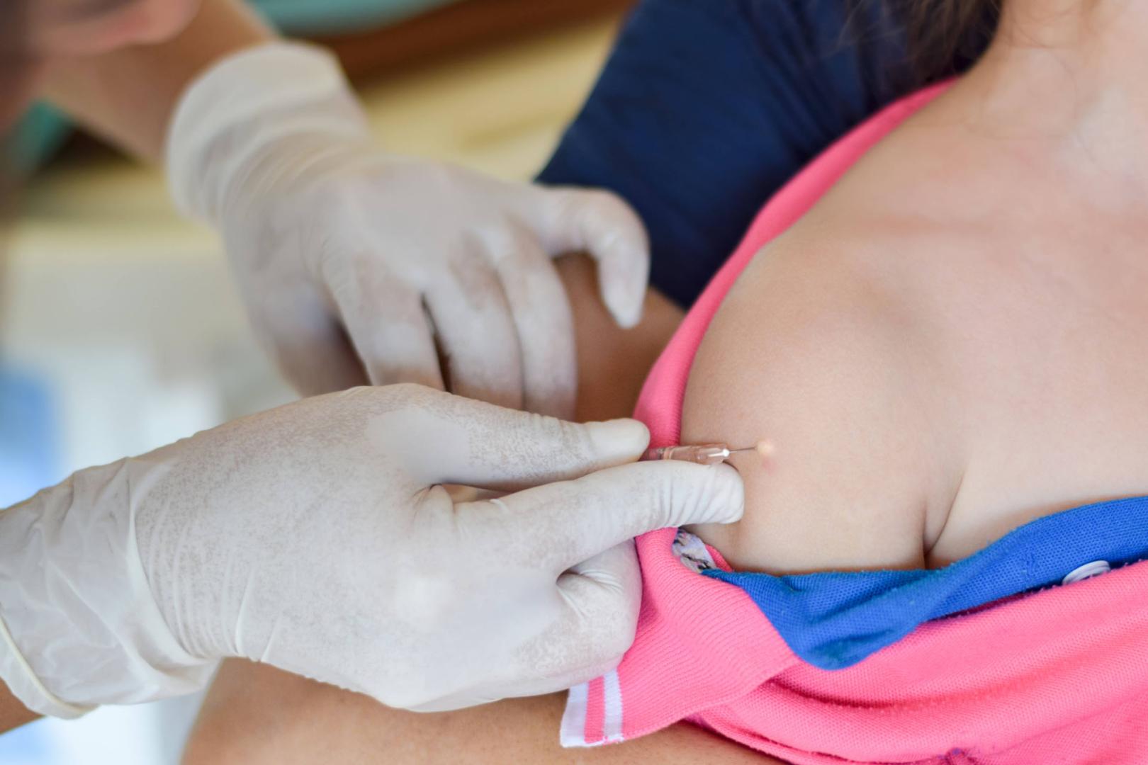 Un médico, vacunando a un niño.
