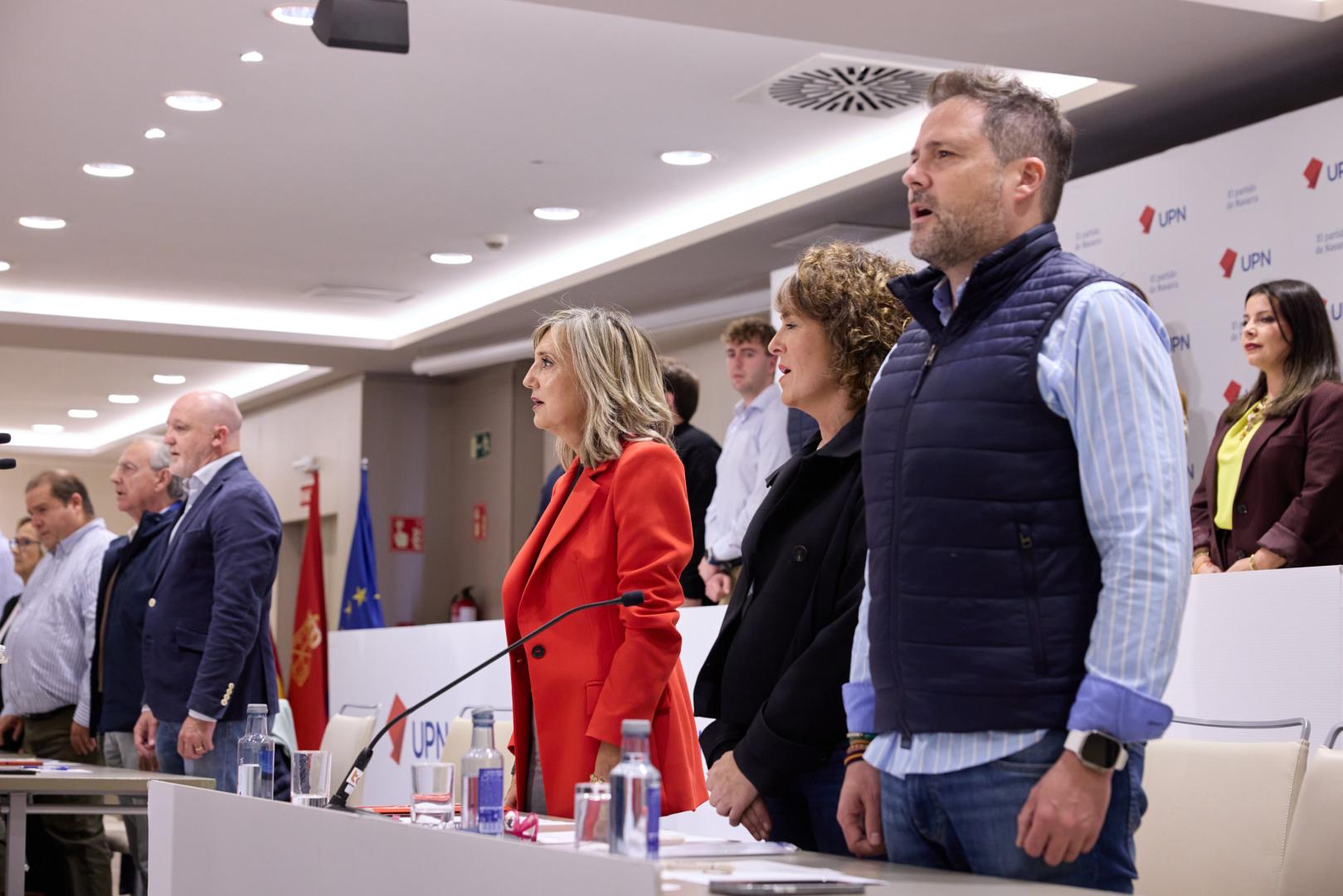Cristina Ibarrola (en el centro) y Alejandro Toquero (primero por la derecha) cantan el himno de Navarra durante un Consejo Político de UPN. Entre ambos, Cristina Sota. A la izquierda, Javier Esparza y Miguel Sanz