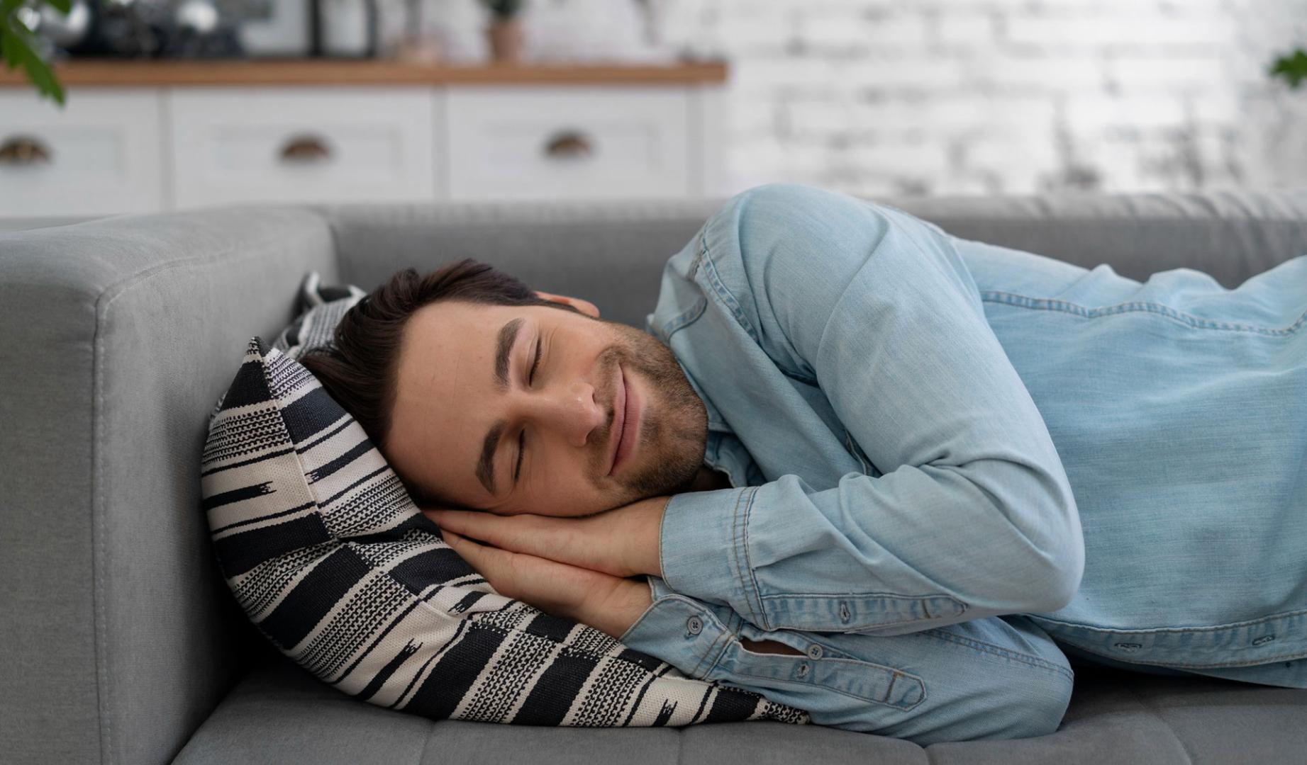 Imagen de archivo de un hombre echándose la siesta en el sofá