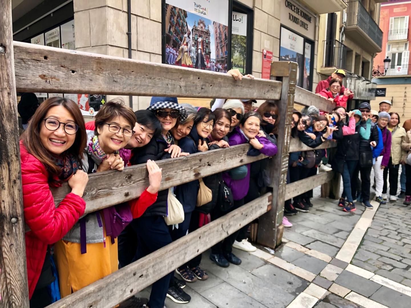 Un grupo de japoneses en el vallado fijo del encierro de la plaza del Ayuntamiento de Pamplona.