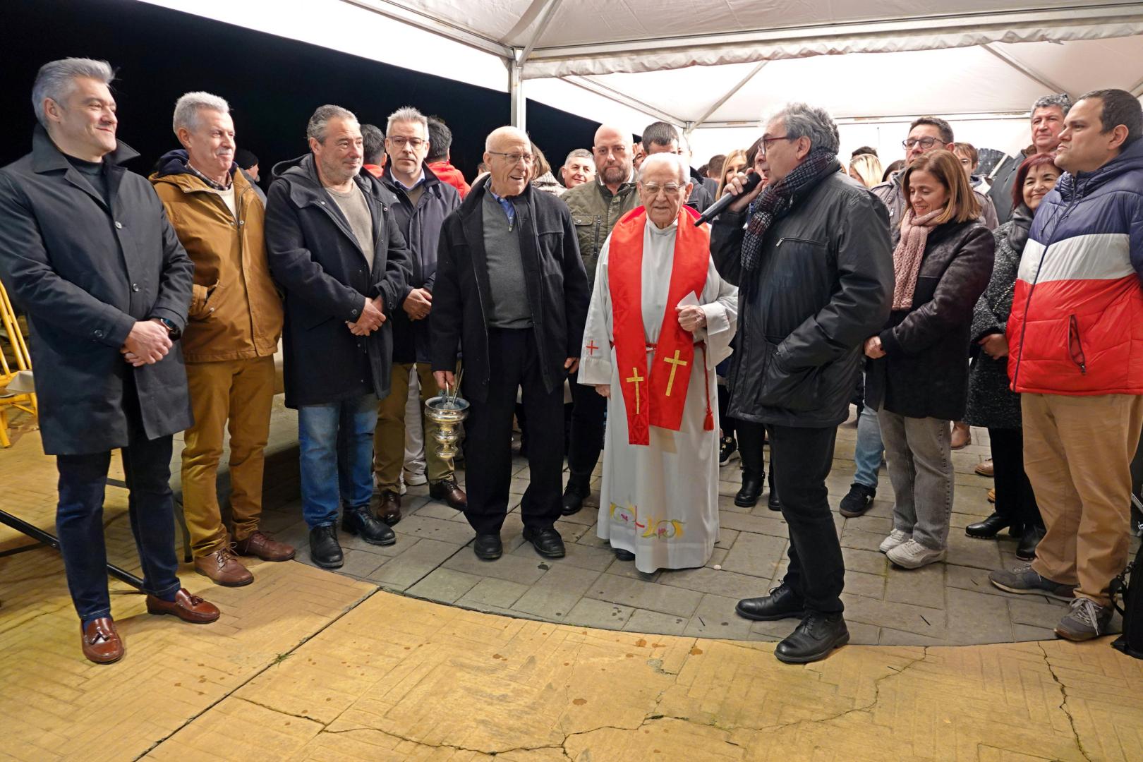 Belén Cerdán, segunda por la derecha, este lunes 2 de febrero, mientras habla el alcalde José Ignacio Pardo, en el día en el que se celebró el reparto de roscos y la hoguera por las fiestas de San Blas de Milagro. Entre los asistentes, el consejero José Luis Arasti (tras el párroco).