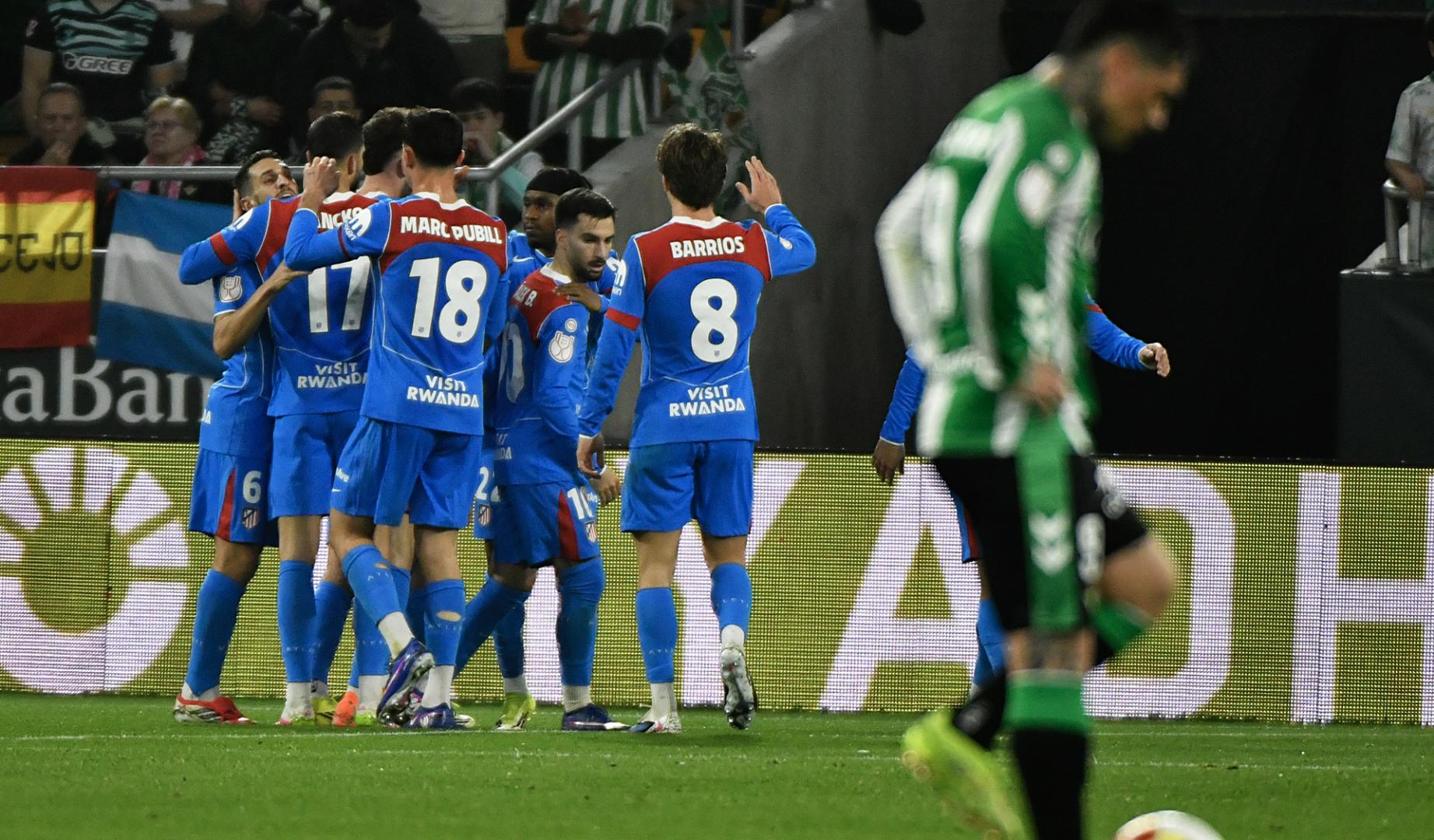 Los jugadores colchoneros celebran uno de los tantos ante la desolación del bético Chimy Ávila