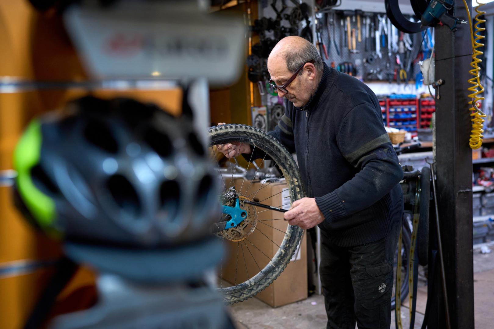 Rufino Hernaiz retira el pasador de la rueda trasera a la bicicleta de un cliente