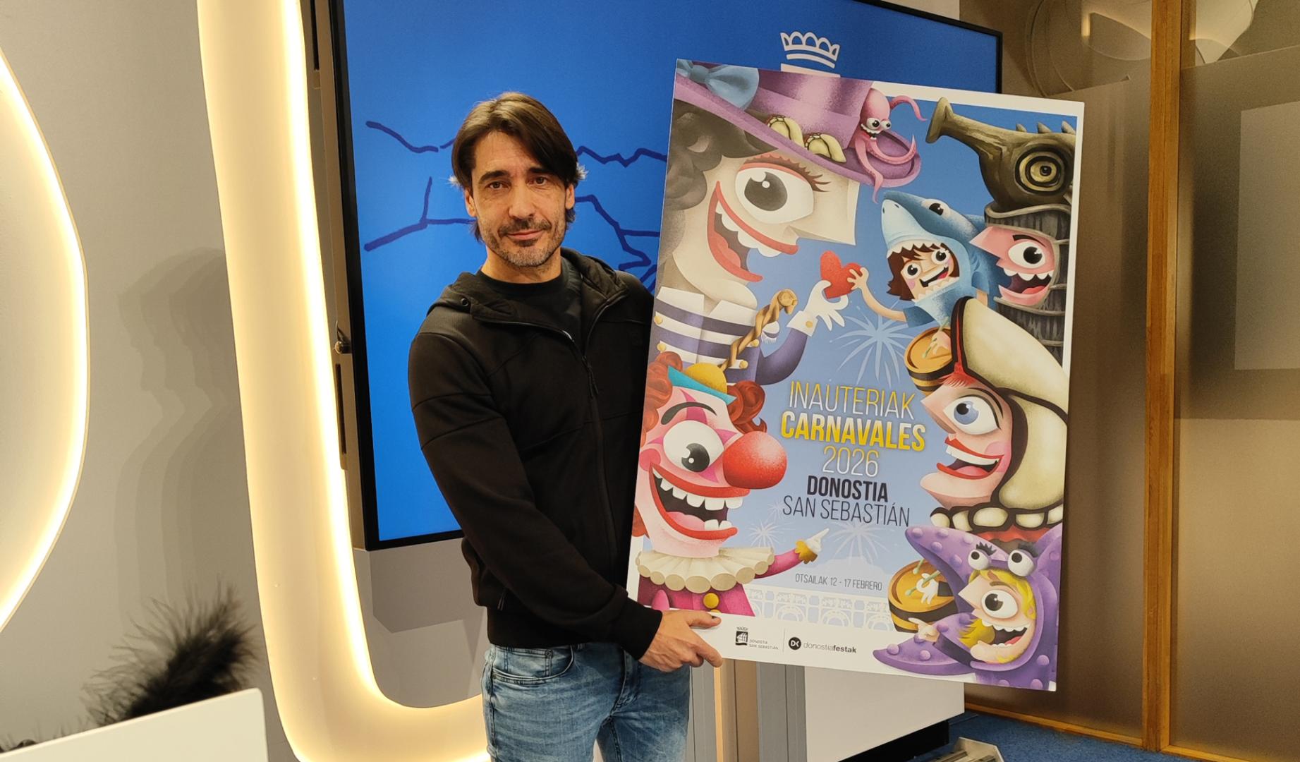 Raúl López Martín posa con el cartel que ha diseñado para los carnavales donostiarras de 2026