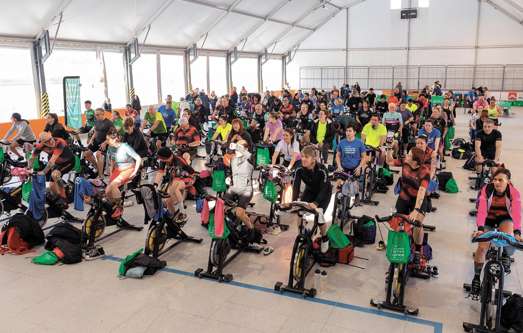 Los participantes en el maratón solidario de spinning pedalean en el patinódromo municipal