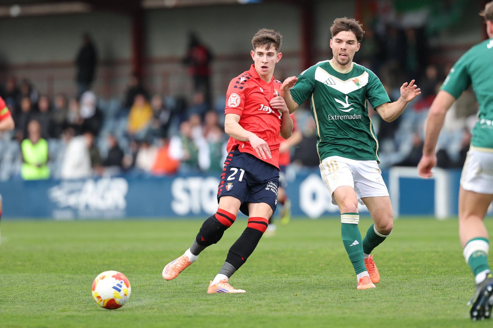 El lateral de Osasuna Promesas Raúl Chasco da un pase en presencia de Javi Ajenjo, del Cacereño