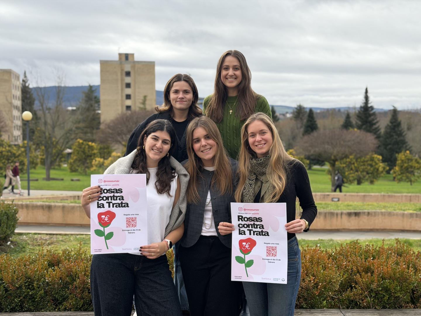 Voluntarias de la Universidad de Navarra posan en el campus con el cartel de 'Rosas contra la trata'.