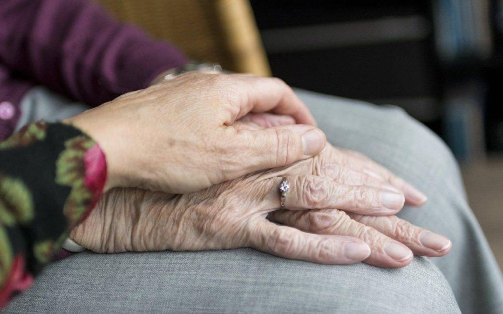 Una mujer toma la mano de una persona dependiente