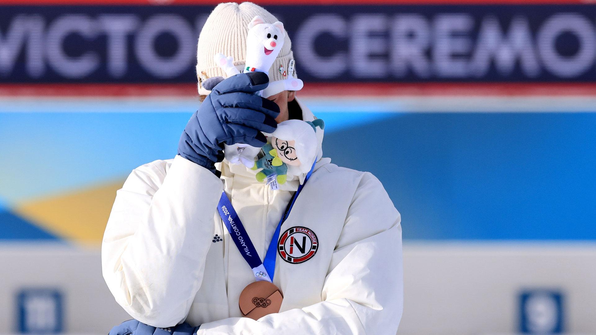 El biatleta noruego Sturla Holm Laegreid se emociona en el podio tras lograr la medalla de bronce en los Juegos Olímpicos de Invierno Milán-Cortina 2026
