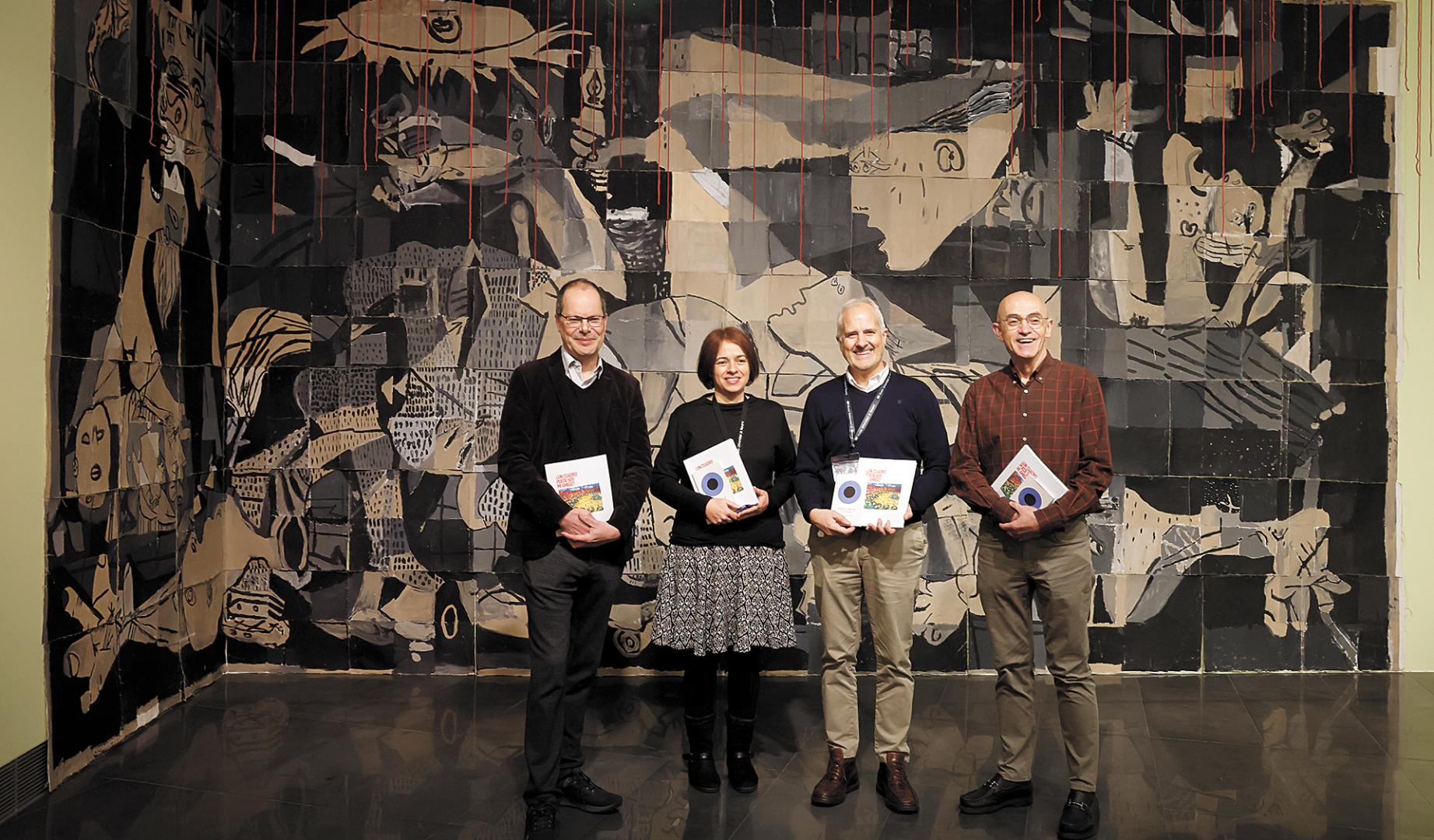 De izda a dcha: Gabriel Pérez-Barreiro, Teresa Barrio,  Fernando Echarri e Ignacio Miquéleiz. Detrás, el mural sobre el Guernica, con hilos rojos  para colocar mensajes de paz