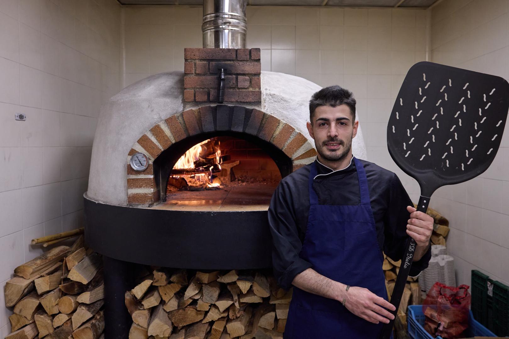 Matteo Urrazza, junto al horno de leña de su pizzería Ad Astra, en la calle Monasterio de la Oliva 3 en Pamplona