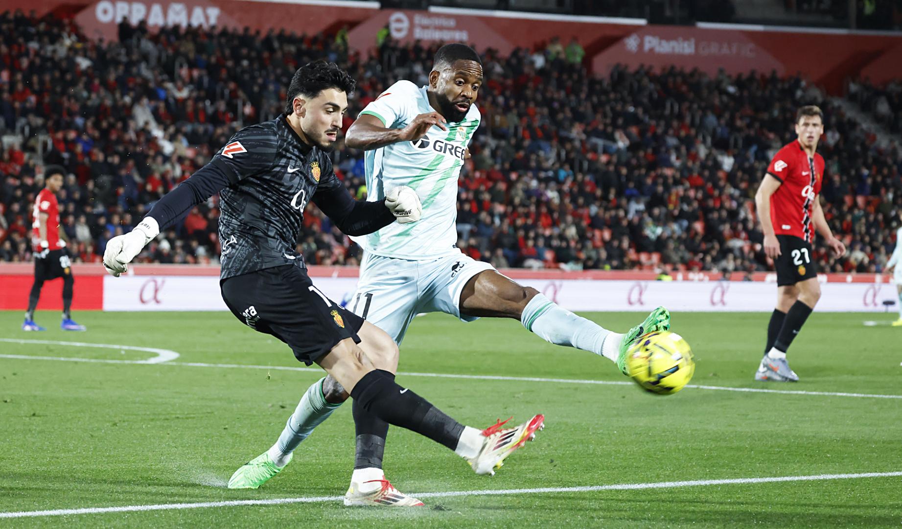 El delantero francés del Betis Cédric Bakambu presiona al portero del Mallorca Leo Román durante el partido