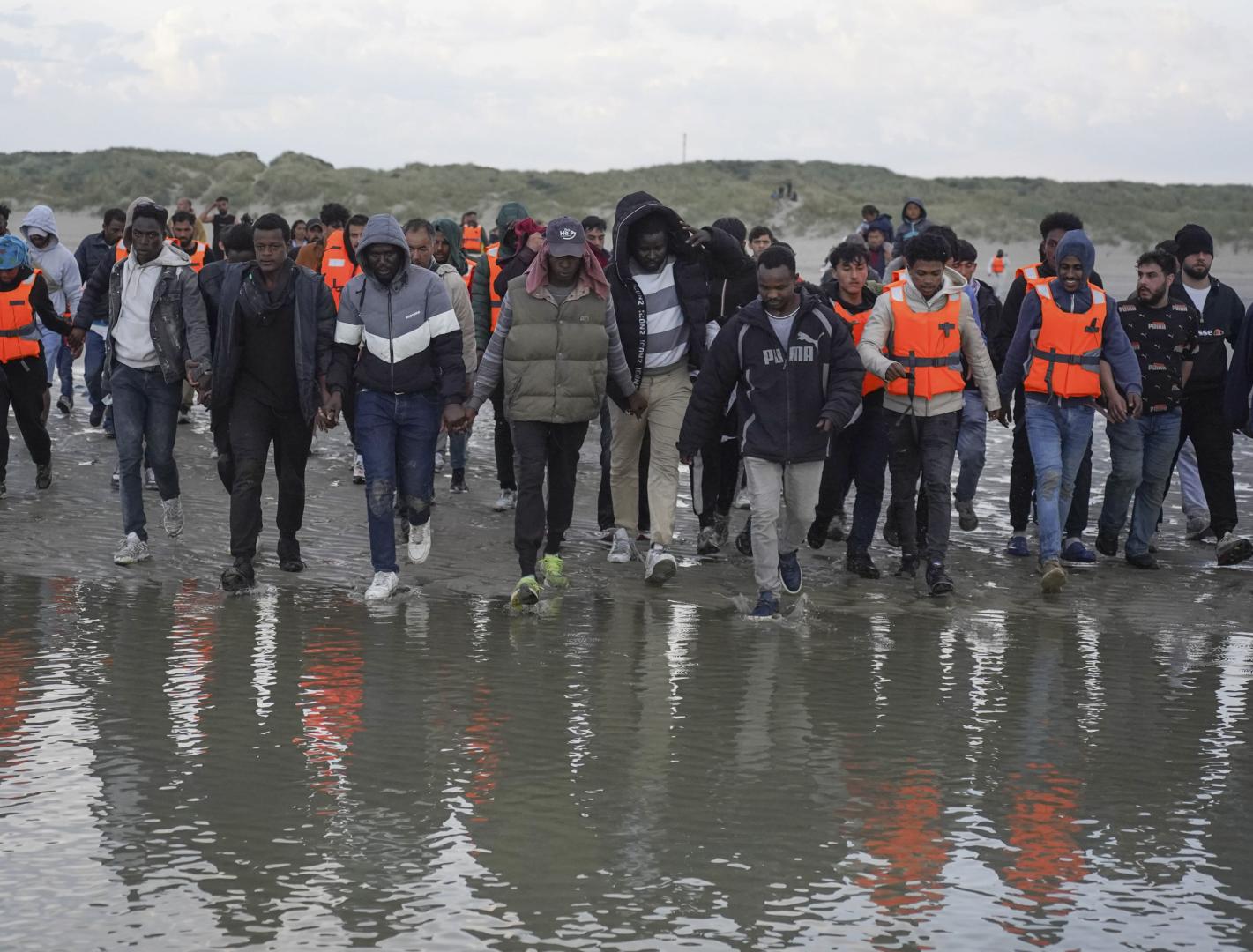 Un grupo de migrantes en Gravelinas (Francia) se adentran el pasado mes de agosto en el mar para subirse a un bote y cruzar el Canal de la Mancha hacia el Reino Unido