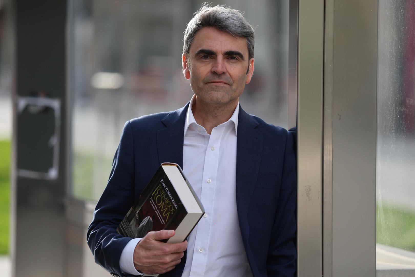 Juan Torres Zalba, retratado en el centro de Pamplona con un ejemplar de 'Enemigos de Roma'