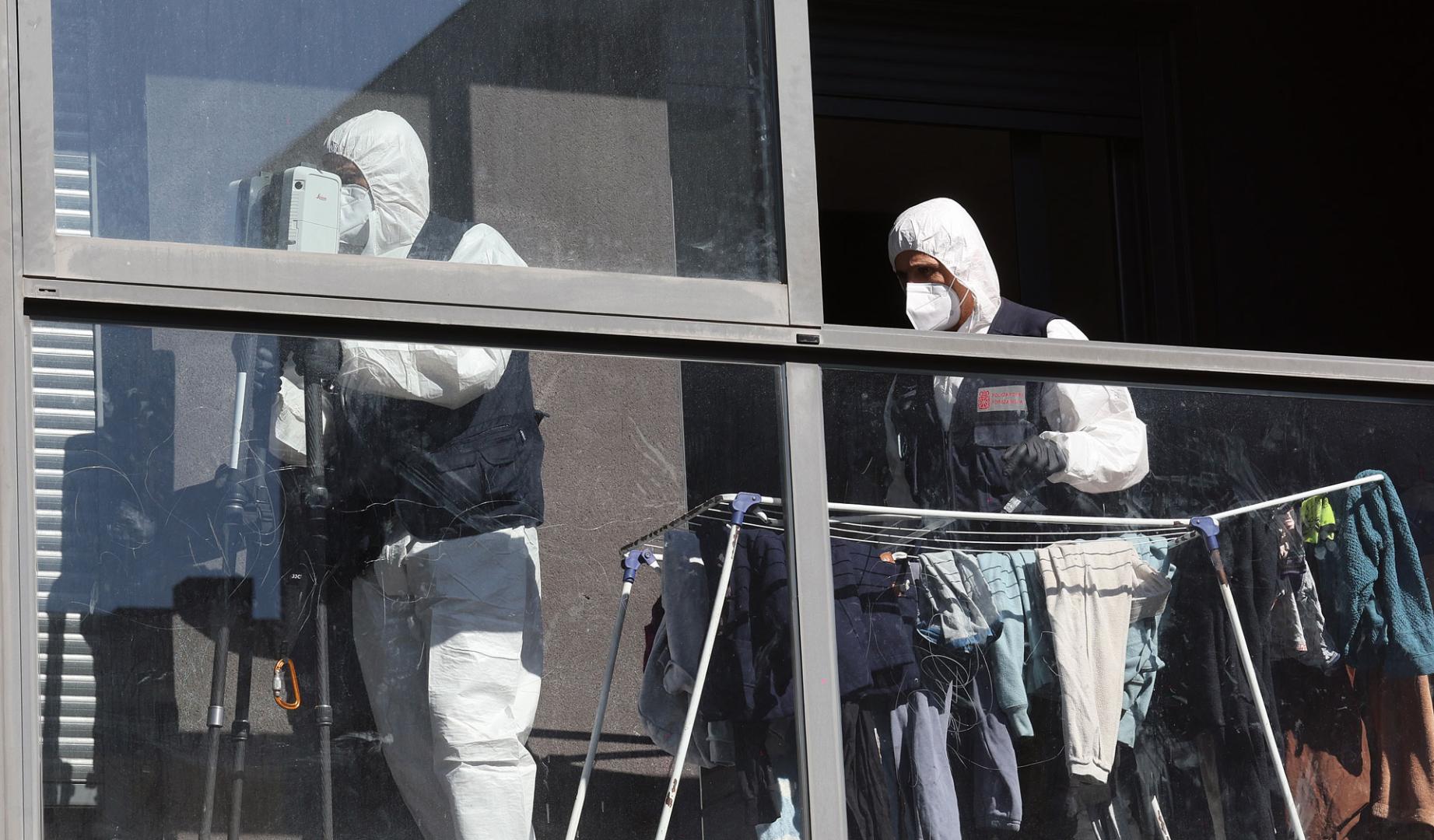 Efectivos de la  Policía Científica de Policía Foral, en el piso en el que se produjo el asesinato de una mujer a manos de su marido en Sarriguren