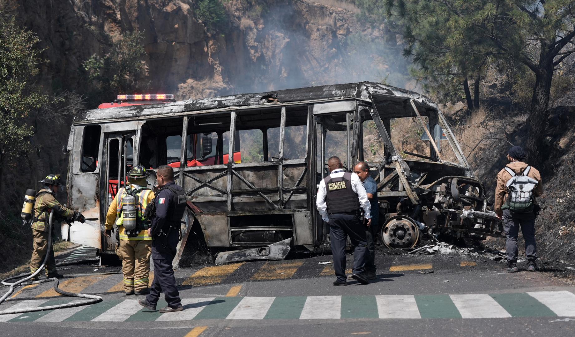 Bomberos e integrantes de la policía de Morelia trabajan en la zona donde fue incendiado un autobús por presuntos integrantes del crimen organizado este domingo,  tras el abatimiento de Nemesio Oseguera Cervantes, alias El Mencho, líder del Cártel Jalisco Nueva Generación (CJNG), en Morelia