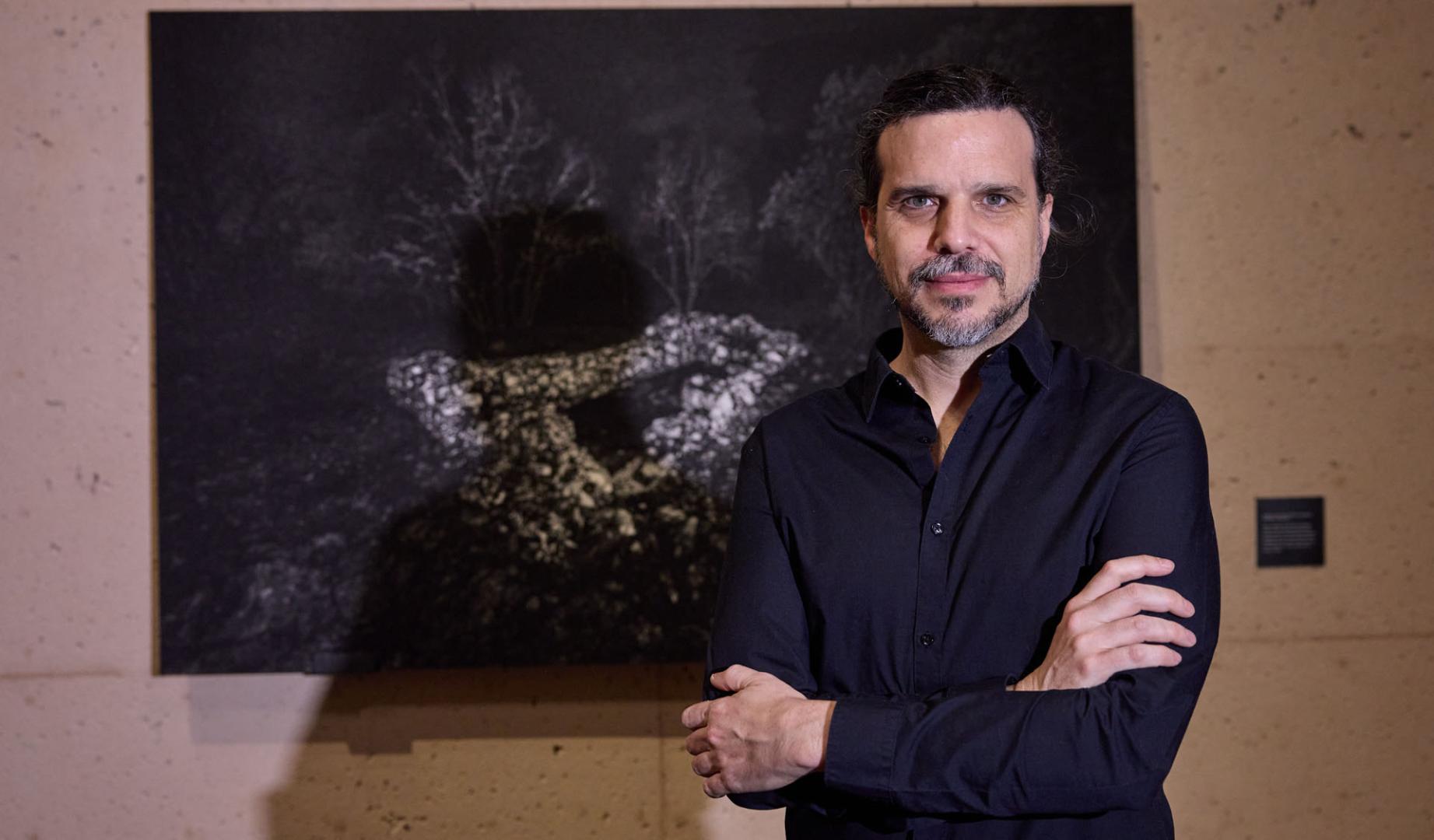 El artista Nicolás Combarro, junto a una de las fotografías del proyecto ‘Materia de silencio’